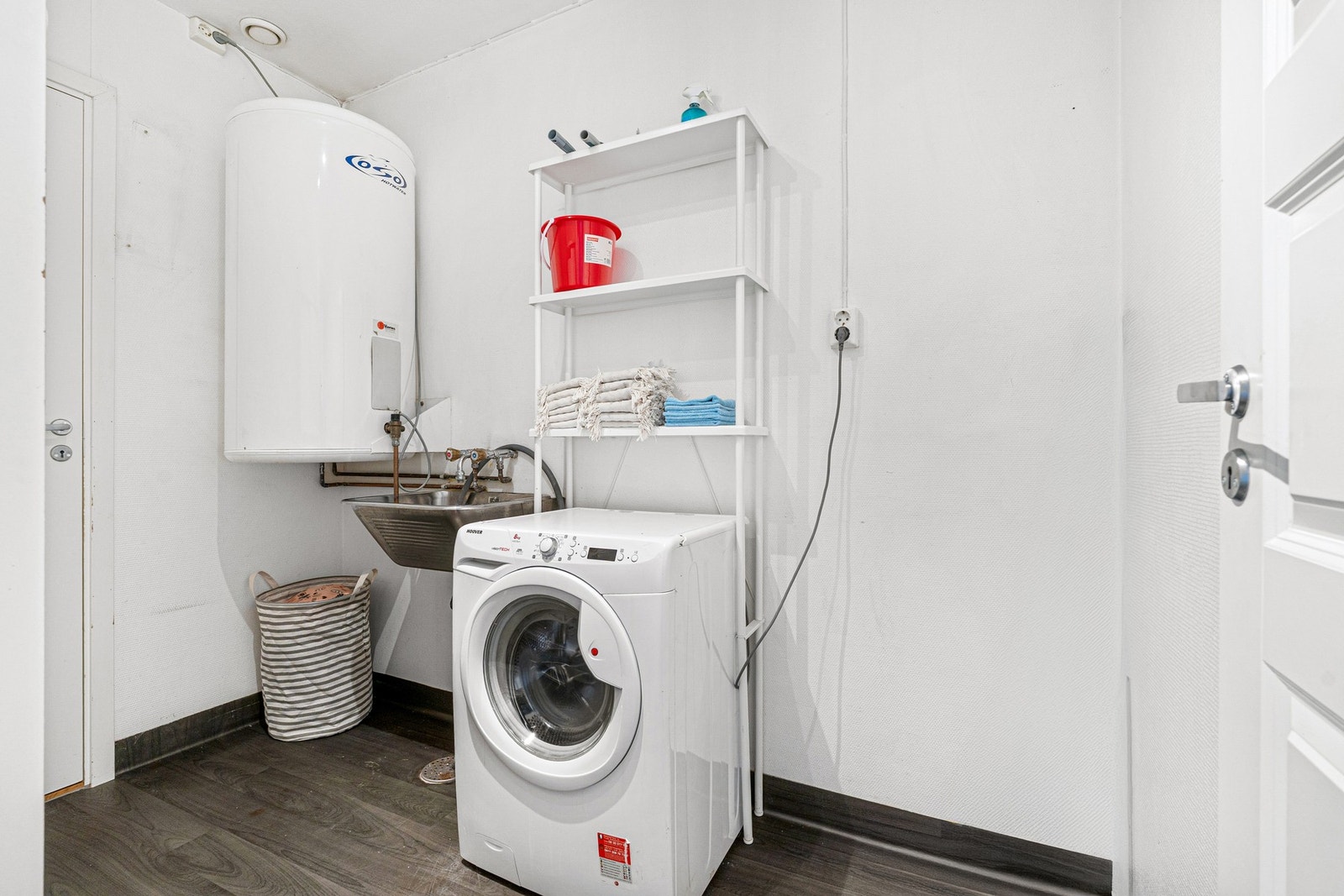 Praktisk vaskerom med opplegg for vaskemaskin og mulighet for ekstra lagringsplass. Galleribilde