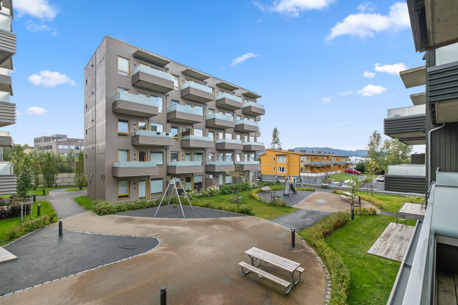 Pent opparbeidet tun over parkeringskjelleren med lekeapparater, sittegrupper og fine internstier. Galleribilde