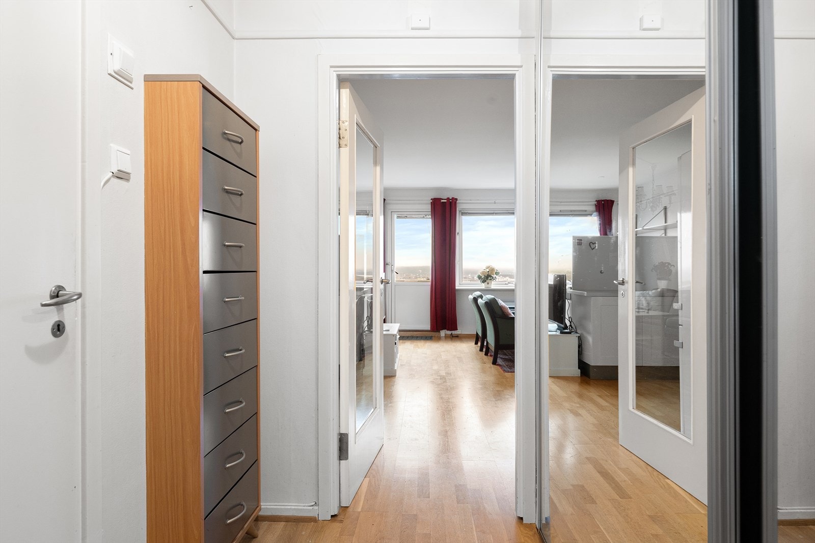 Leiligheten har en lys entré med god plass til yttertøy og sko i skyvedørsgarderobe med speilfronter. Galleribilde