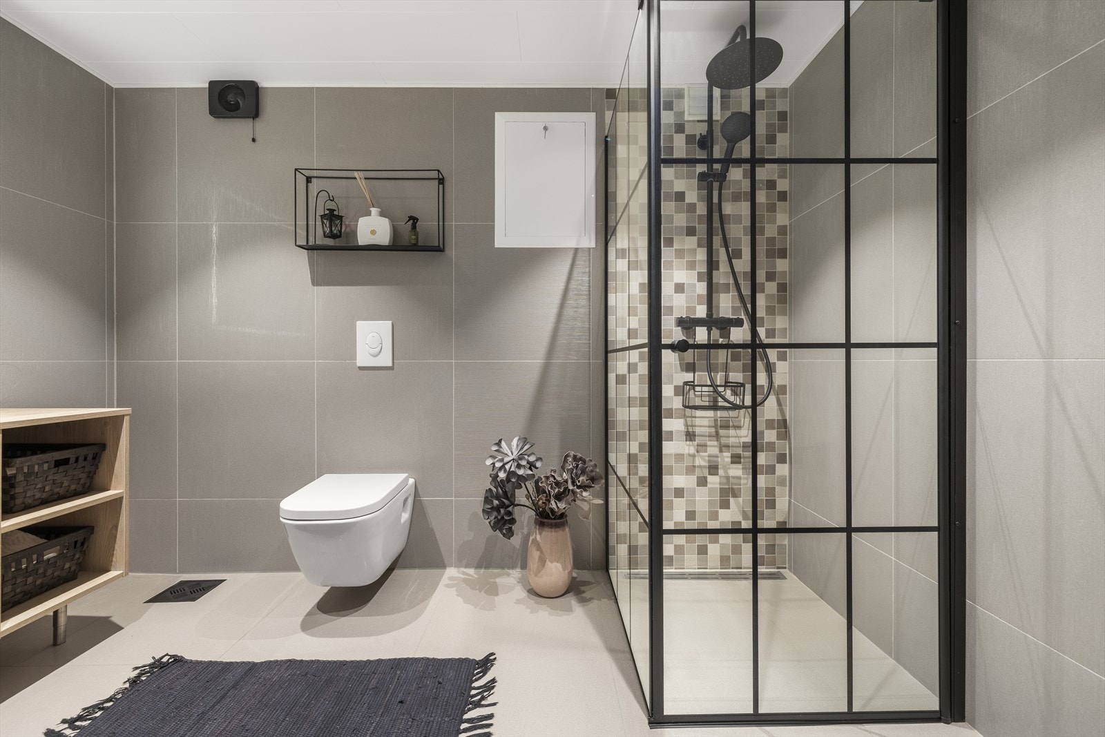 Rommet er utstyrt med veggmontert toalett, servant og et dusjhjørne. Galleribilde