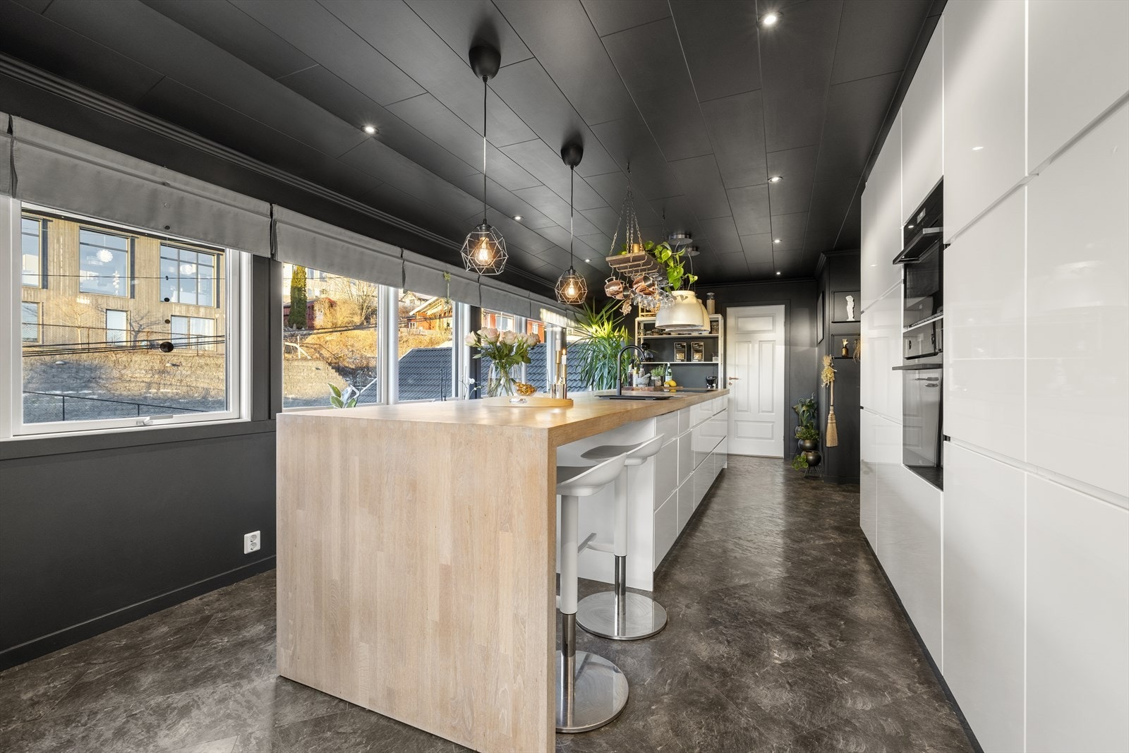 En stor kjøkkenøy med benkeplate i heltre fungerer som en sosial samlingsplass. Galleribilde