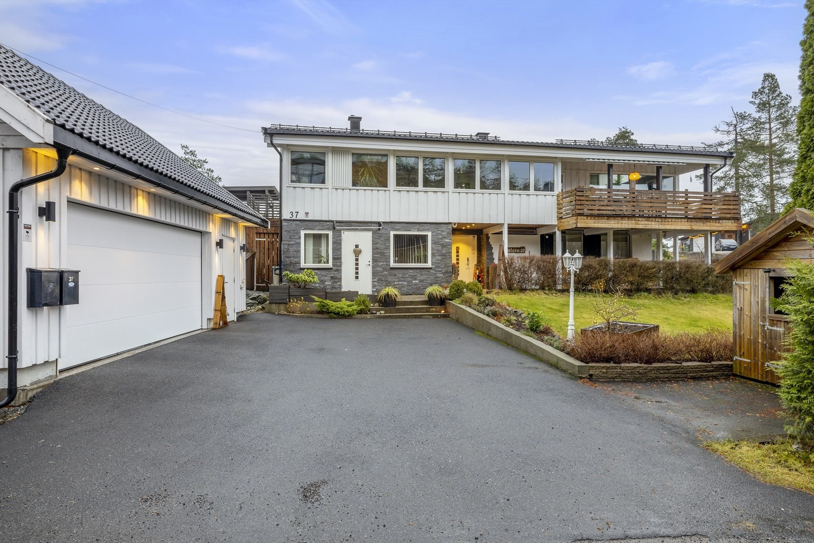 Asfaltert gårdsplass med adkomst til en frittstående dobbelgarasje. Galleribilde