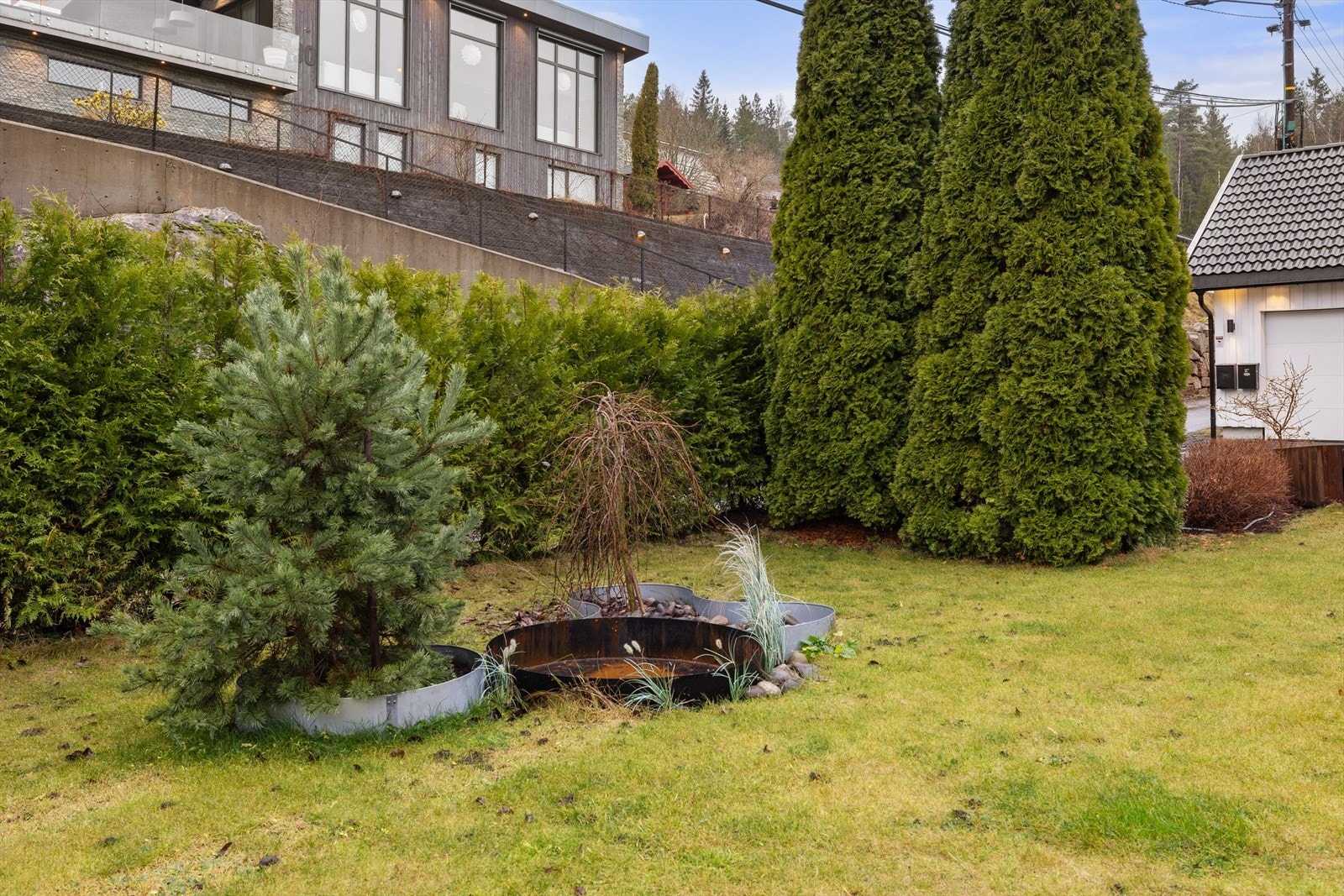 Eiendommen er pent opparbeidet med plen og beplantning. Galleribilde