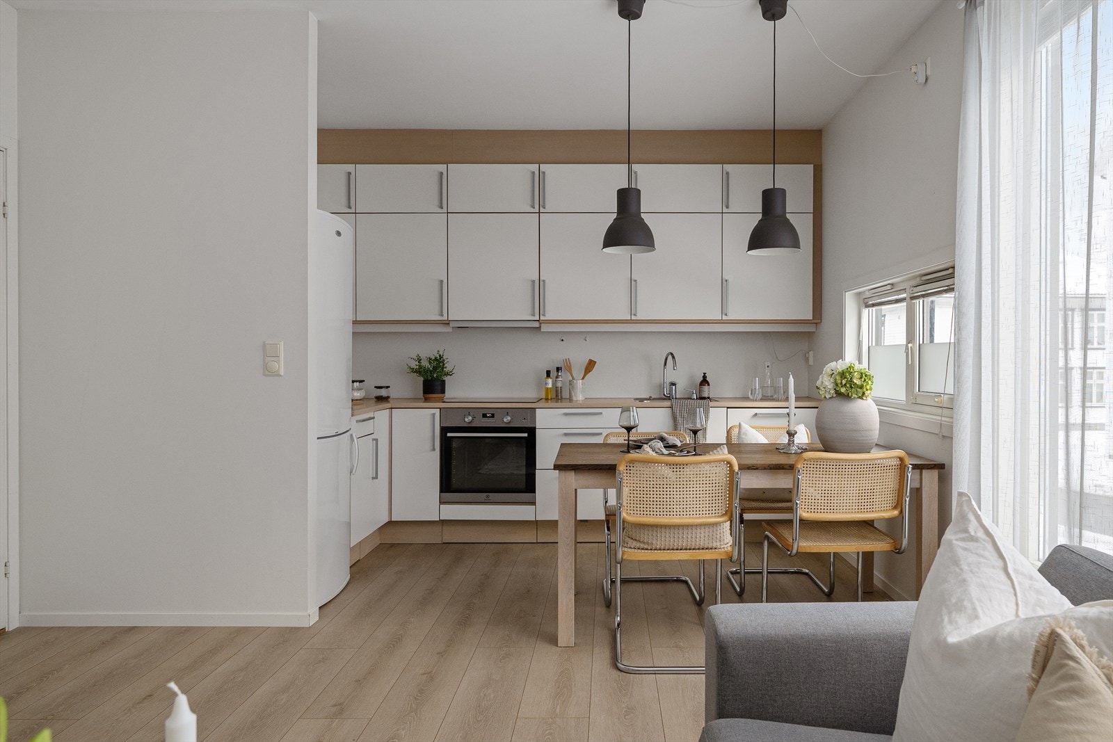 Pent kjøkken utført med hvite fronter og god benk-skapplass. Galleribilde