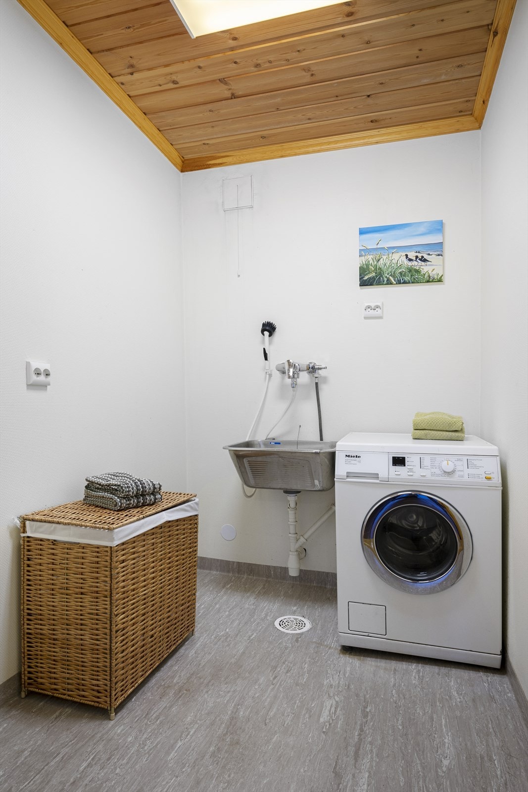 Vaskerom med vinylbelegg på gulv og elektriske varmekabler. Vaskerommet har adkomst fra hallen, perfekt om man har små barn eller hund Galleribilde