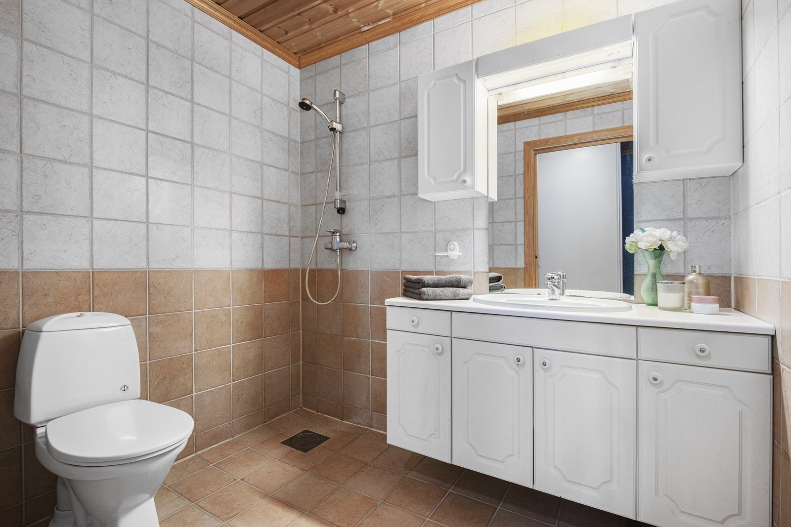 Helfliset bad i 2. etasje med elektriske varmekabler i gulv. Innredet med toalett, dusj og baderomsinnredning Galleribilde