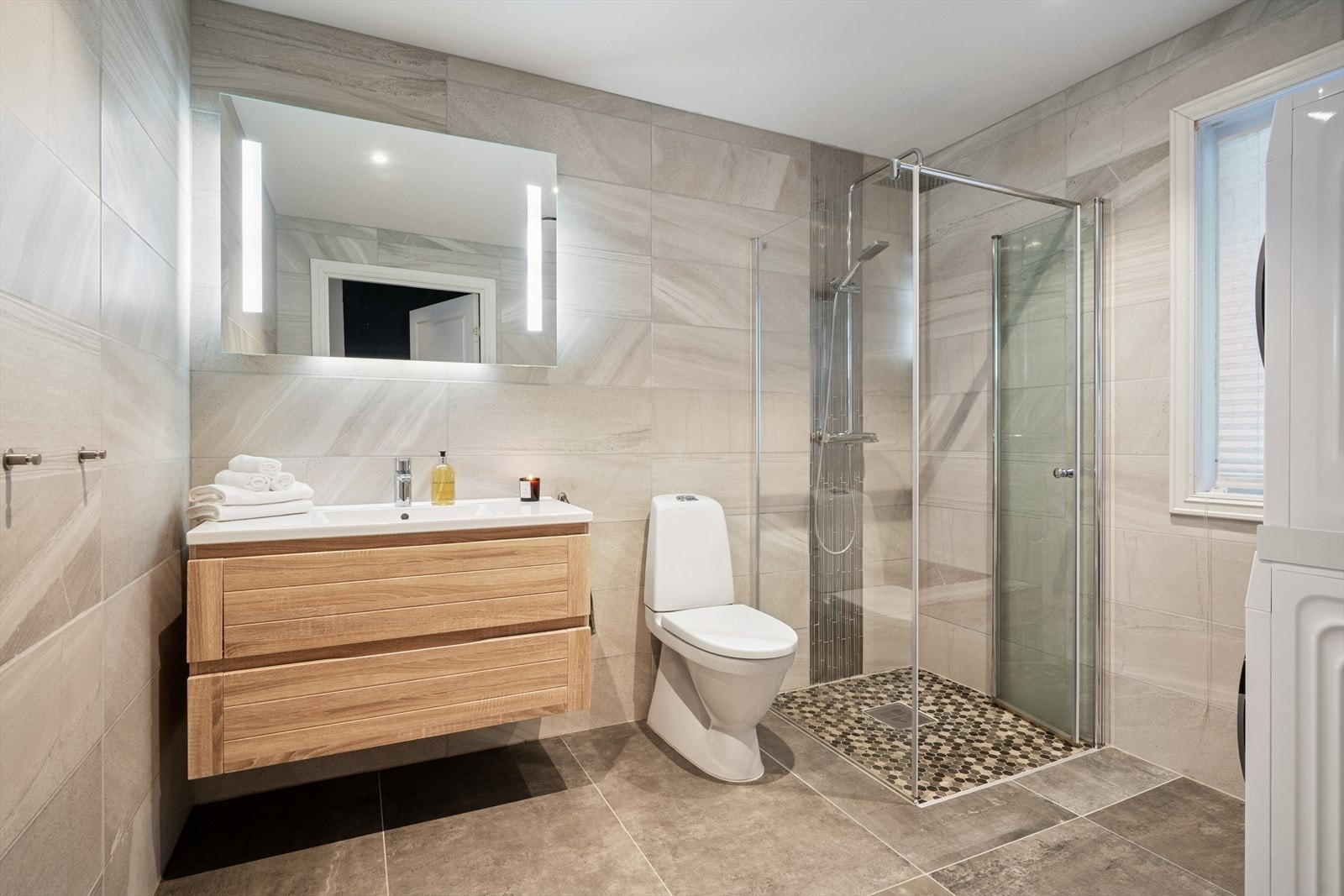 Badet er moderne og av god størrelse med flislagte overflater Galleribilde