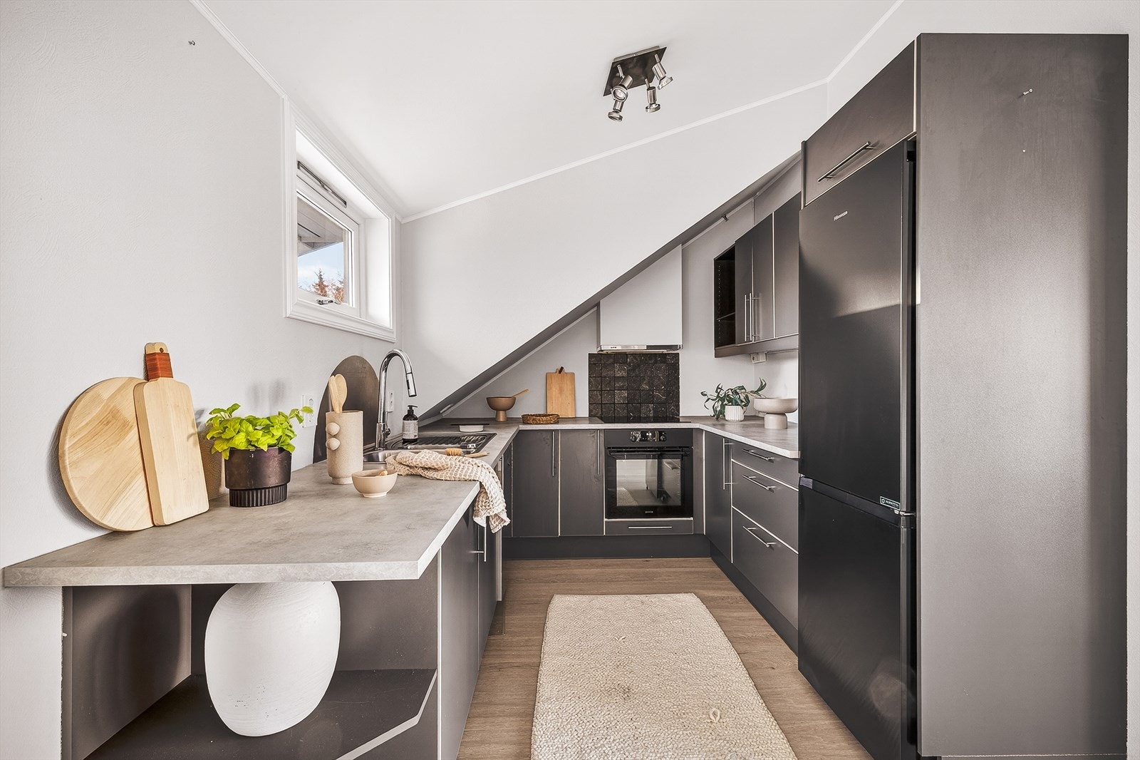 Tidløs innredning med integrerte hvitevarer og frittstående kjøleskap. Galleribilde