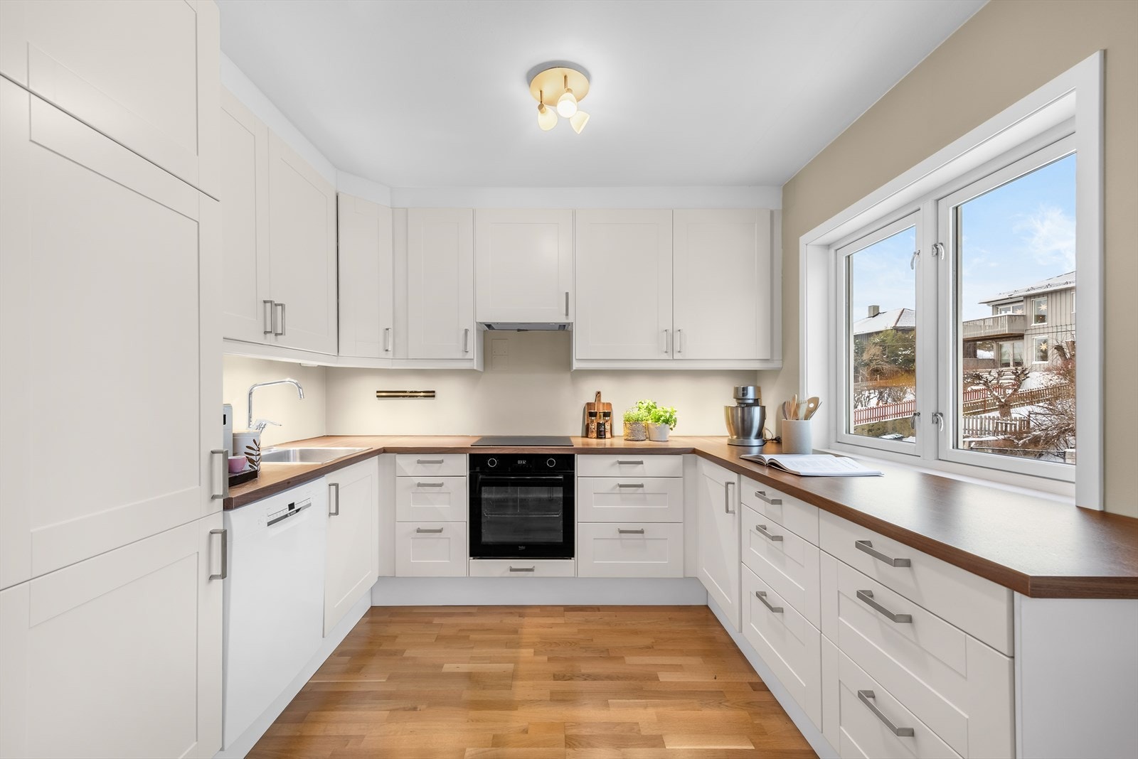 Et velholdt og pent kjøkken fra 2011 med integrerte hvitevarer; platetopp, stekeovn og kjøl-/fryseskap, i tillegg til opplegg for oppvaskmaskin. Varmtvannsbereder på ca. 120 liter er plassert i kjøkkeninnredningen. Galleribilde