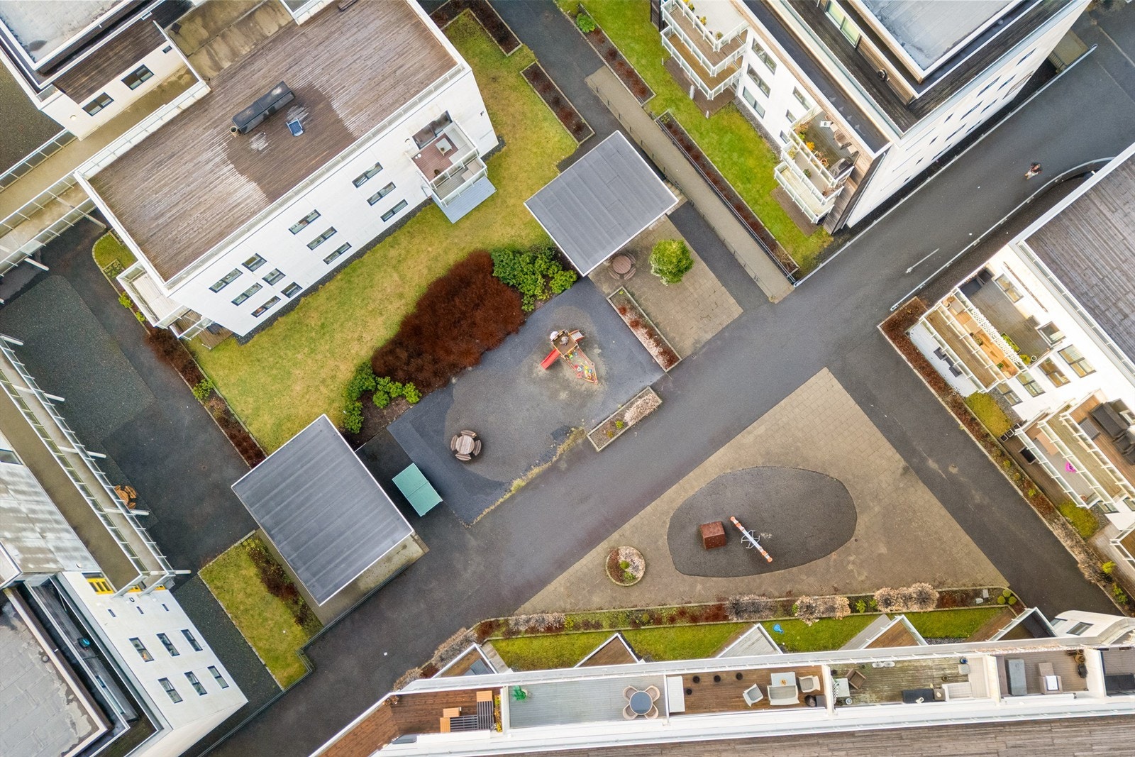 Sameiets fellesareal er pent opparbeidet med grøntareal og beplantning, samt fine sosiale soner med sittegrupper og lekeapparater Galleribilde