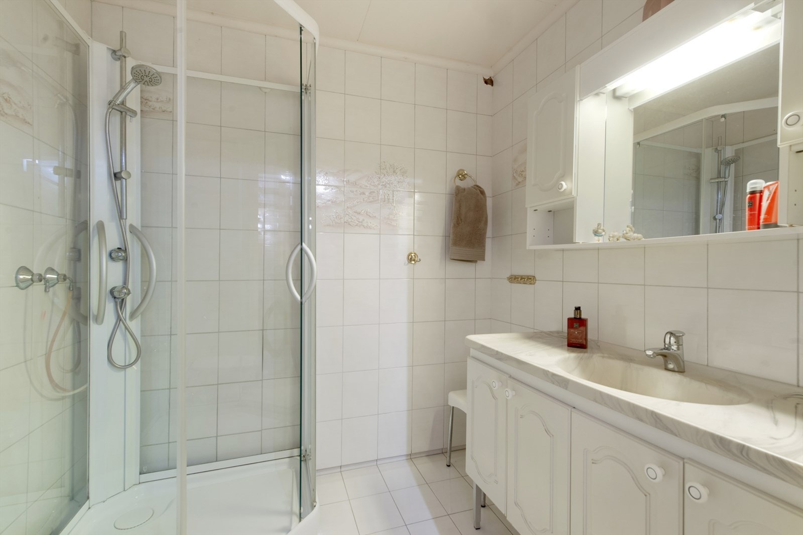 Baderommet i underetasjen er av eldre dato og er utstyrt med klosett, dusjkabinett med glassdører og en hel servantplate med underskap. Galleribilde