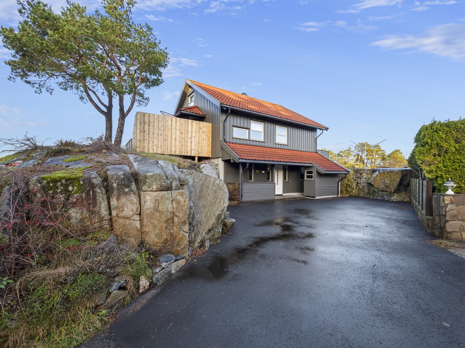 Romslig, nyasfaltert gårdstun og inngangsparti. Galleribilde