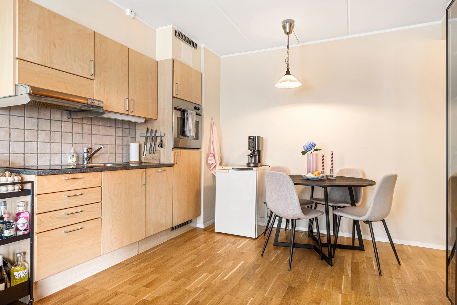 Kjøkken med integrerte hvitevarer og plass til spisegruppe Galleribilde