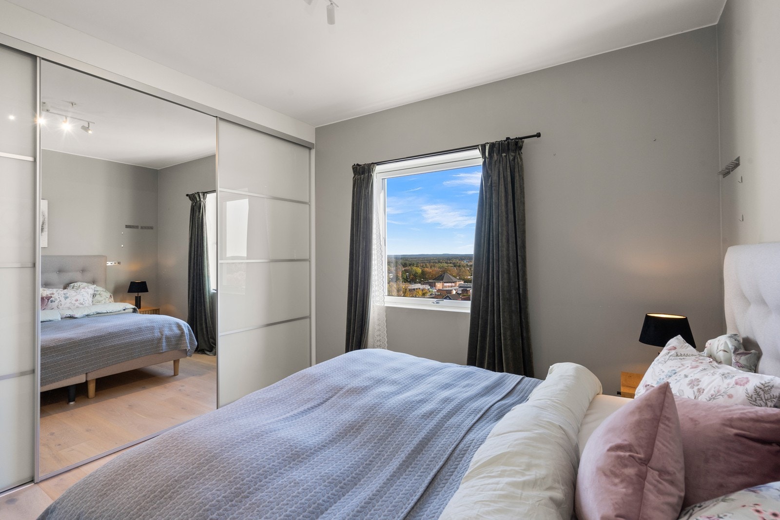 En romslig skyvedørsgarderobe med speilfronter gir rikelig med oppbevaringsplass. Galleribilde