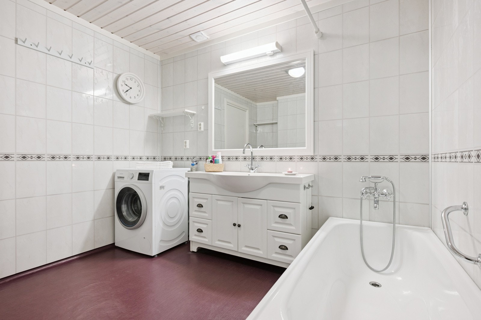 Lys og moderne servant innredning, samt speil med tilhørende belysning. Badekar med dusjopplegg. Galleribilde