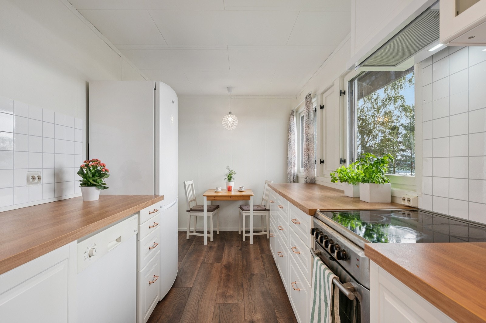 Morderne og lys kjøkkeninnredning fra 2023 med profilerte fronter. Kjøkkenet har rikelig med lagringsplass. Galleribilde