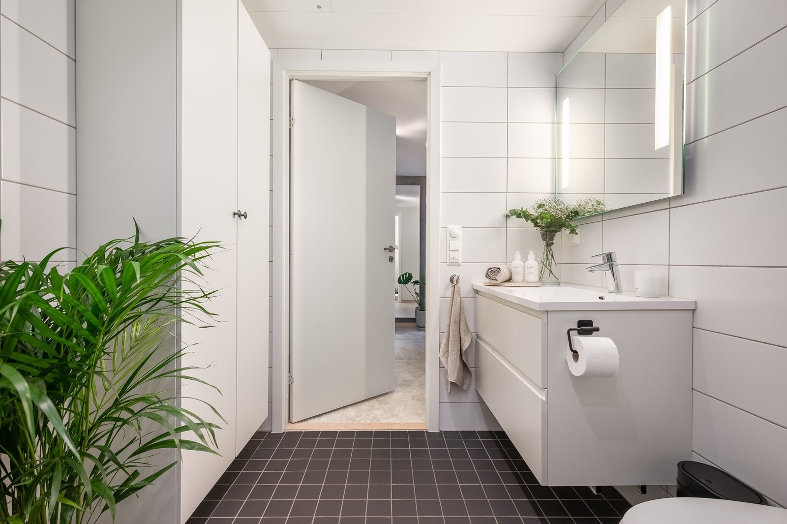 Rommet er innredet med vegghengt toalett, servant med underskap og speil med belysning. Galleribilde