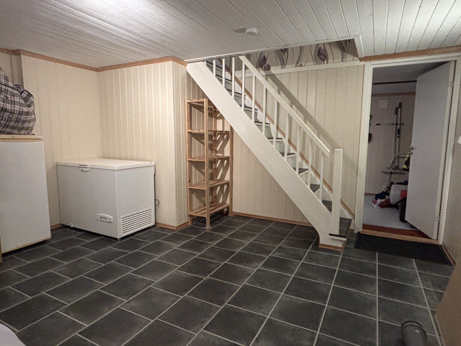 I husets kjeller finner man et stort disponibelt rom, rommet er tidligere brukt som kjellerstue. Galleribilde