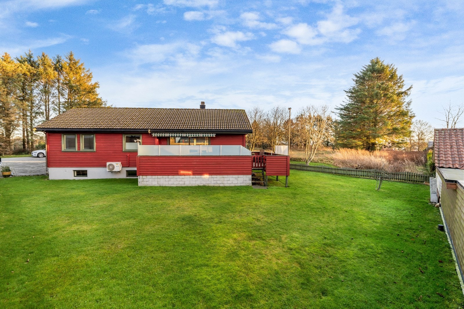 Stor og pent opparbeidet tomt med plen og diverse beplantning Galleribilde