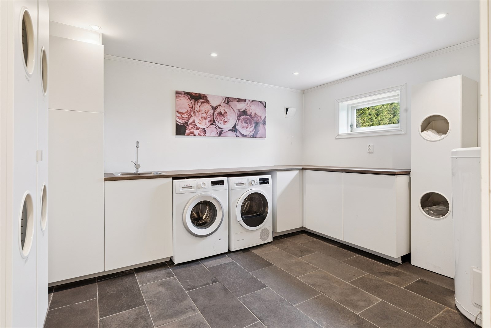 Separat og romslig vaskerom i underetasjen med gode arbeidsflater og opplegg for vaskemaskin. Galleribilde