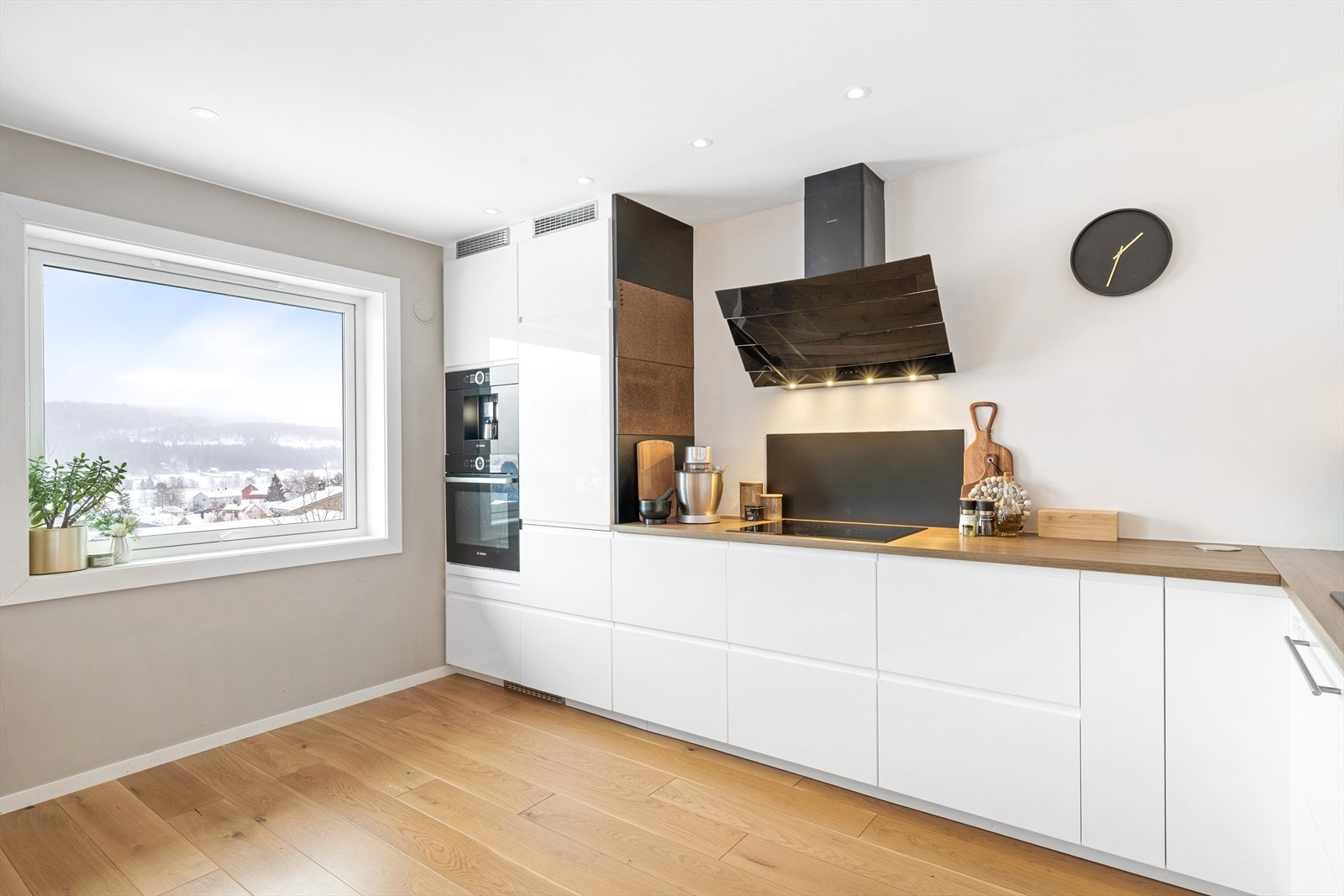 Kjøkkenet er levert med integrerte hvitevarer som blant annet kjøleskap, fryser, induksjonstopp, stekeovn og oppvaskmaskin Galleribilde