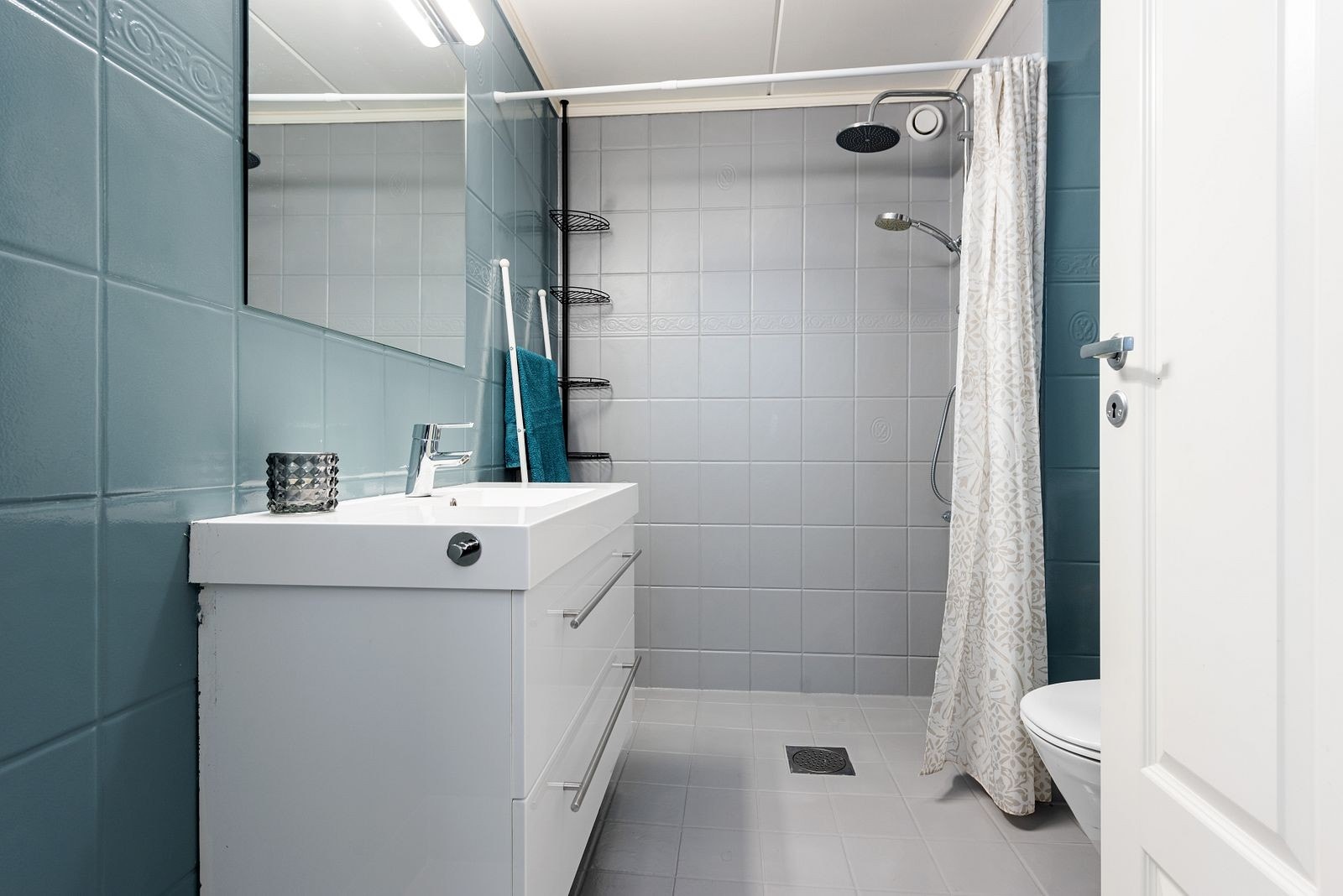 Bad med vaskemaskin og tørketrommel bak døren Galleribilde