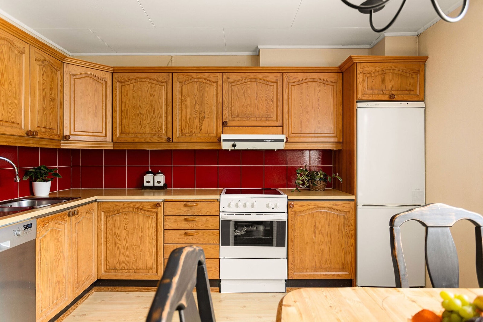 Kjøkkenet er utstyrt med frittstående hvitevarer, oppvaskmaskin under benk og ventilator i overskap. Galleribilde