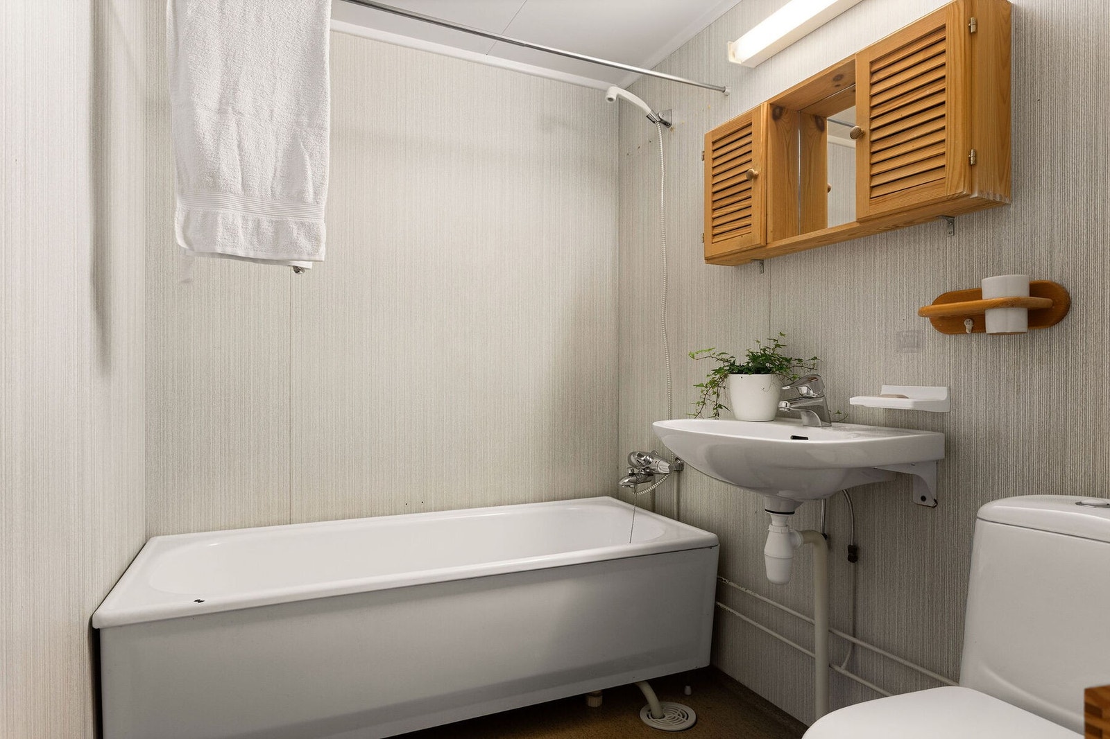 Badet i andre etasje er fra 1977 og inneholder badekar, servant med speilskap, gulvstående toalett og mekanisk avtrekk. Galleribilde