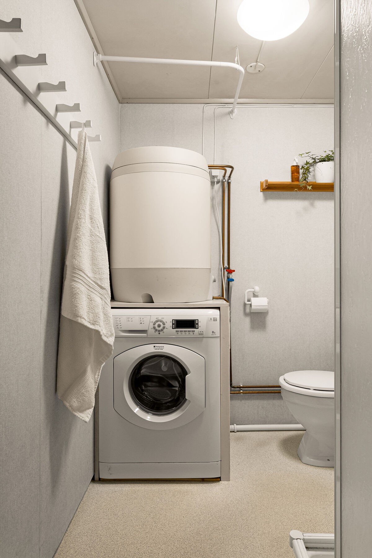 Rommet er innredet med dusjkabinett, servantinnredning, speilskap, gulvstående toalett og opplegg for vaskemaskin. Galleribilde