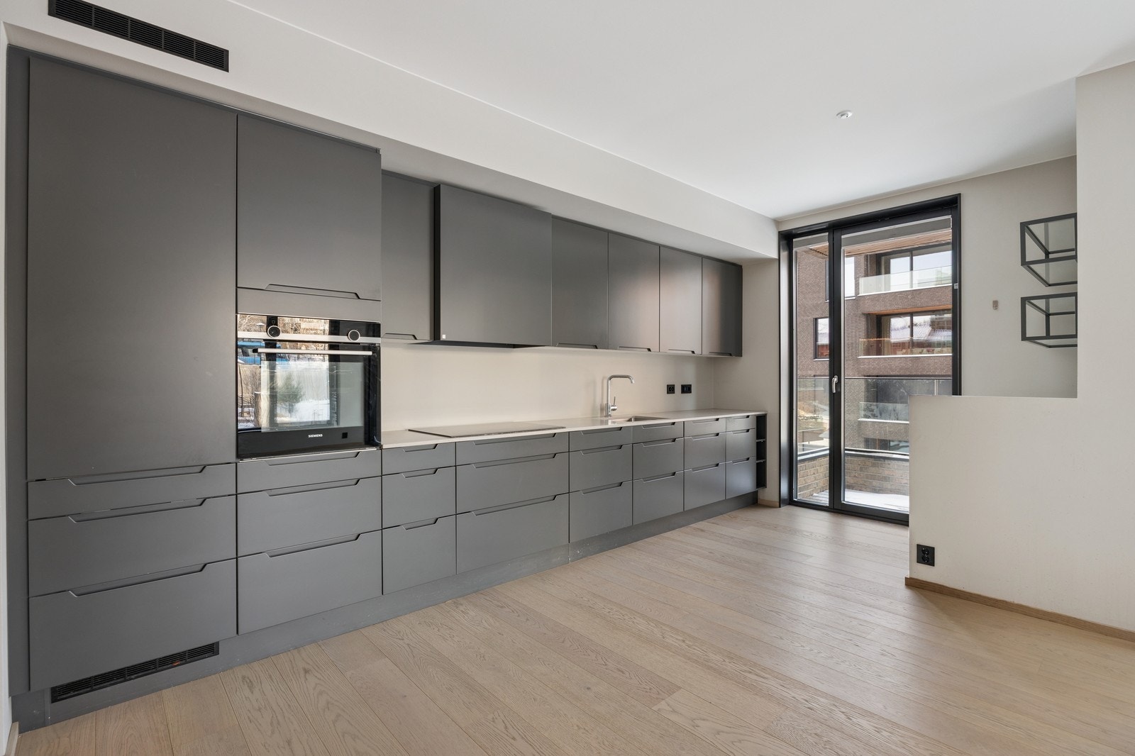 Kjøkken med hvitevarer og utgang til balkong Galleribilde