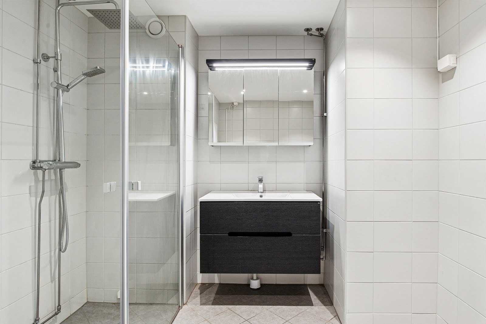 Baderomsinnredningen har slette fronter, heldekkende servant og et praktisk speilskap med belysning. Galleribilde