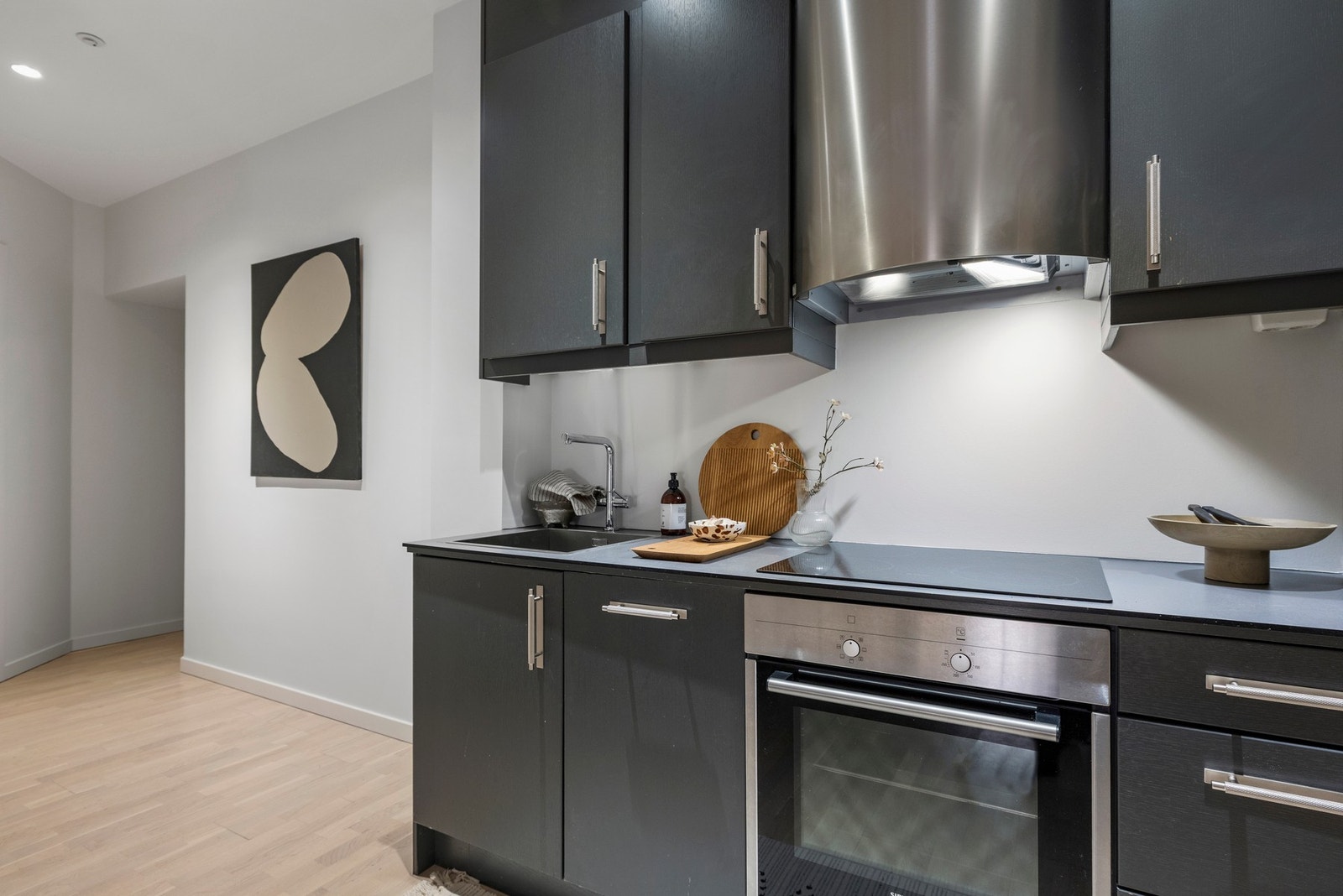 Kjøkkenet er innredet med integrerte hvitevarer som komfyr, induksjon platetopp, oppvaskmaskin og kjøl/frys. Galleribilde