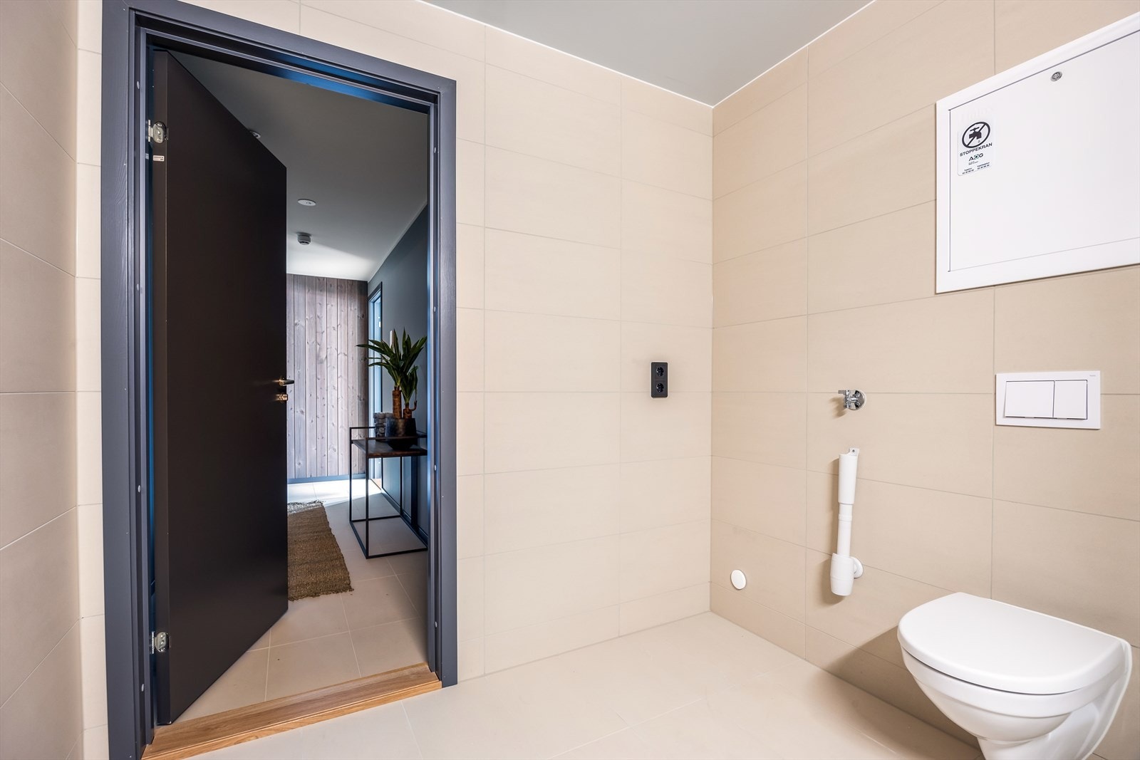 Det flislagte badet er stilrent og funksjonelt, med elektriske varmekabler i gulvet som gir en behagelig varme. Badet har også opplegg for vaskemaskin. Galleribilde