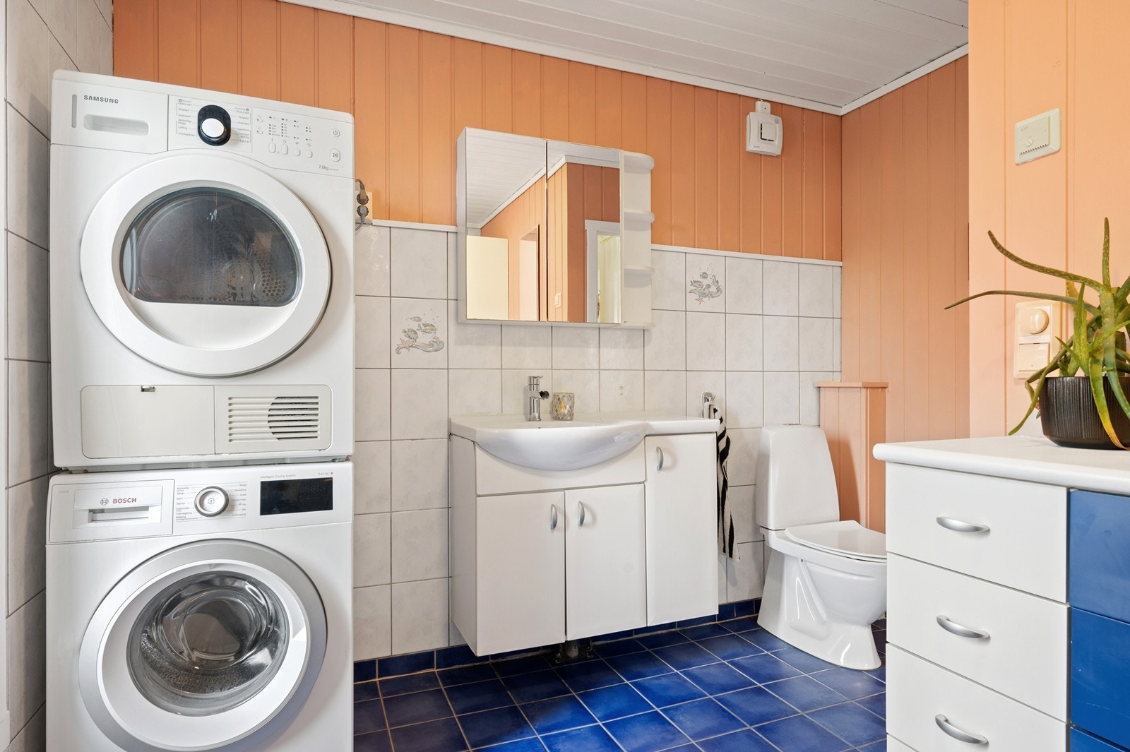 Bad/vaskerom fra 2001. Rommet har innredning med nedfelt servant, gulvfestet toalett, dusjkabinett og opplegg for vaskemaskin. Galleribilde