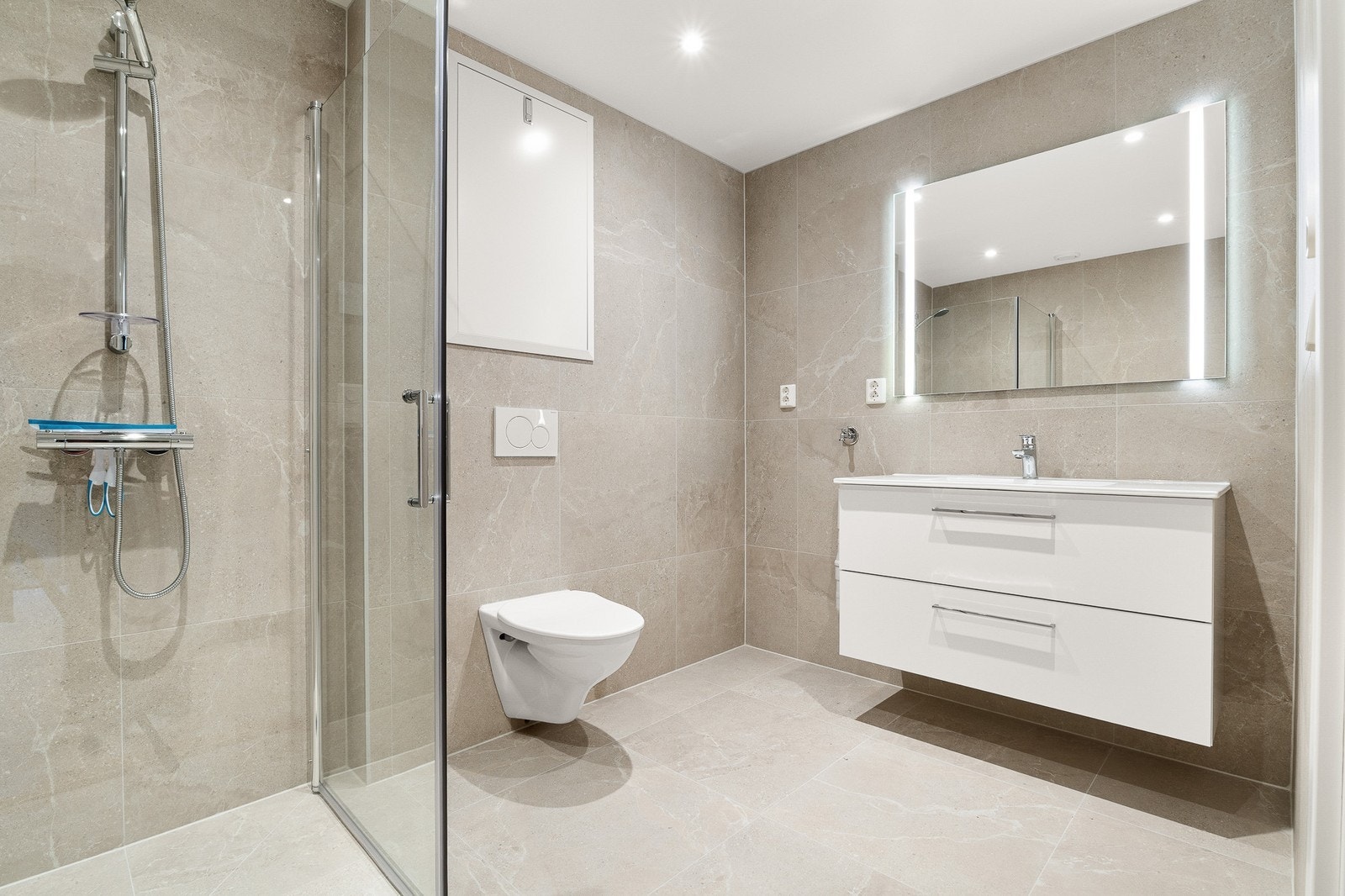 Helfliset og moderne baderom. Inneholder vaskemaskin, wc, dusj og servant | Opplegg til hvitevarer. Galleribilde