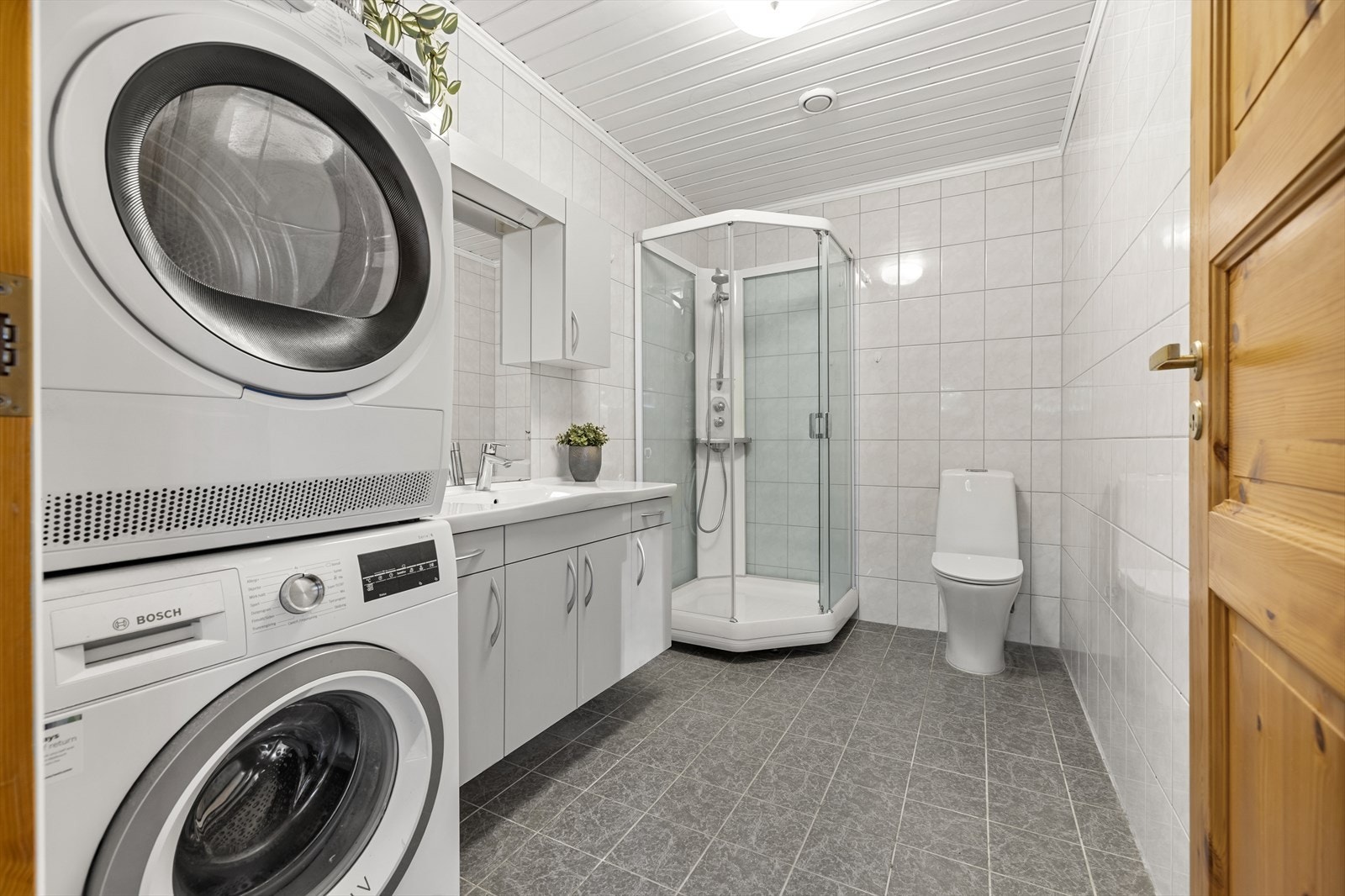 Badet er utstyrt med toalett, servant med skap og dusjkabinett. Galleribilde