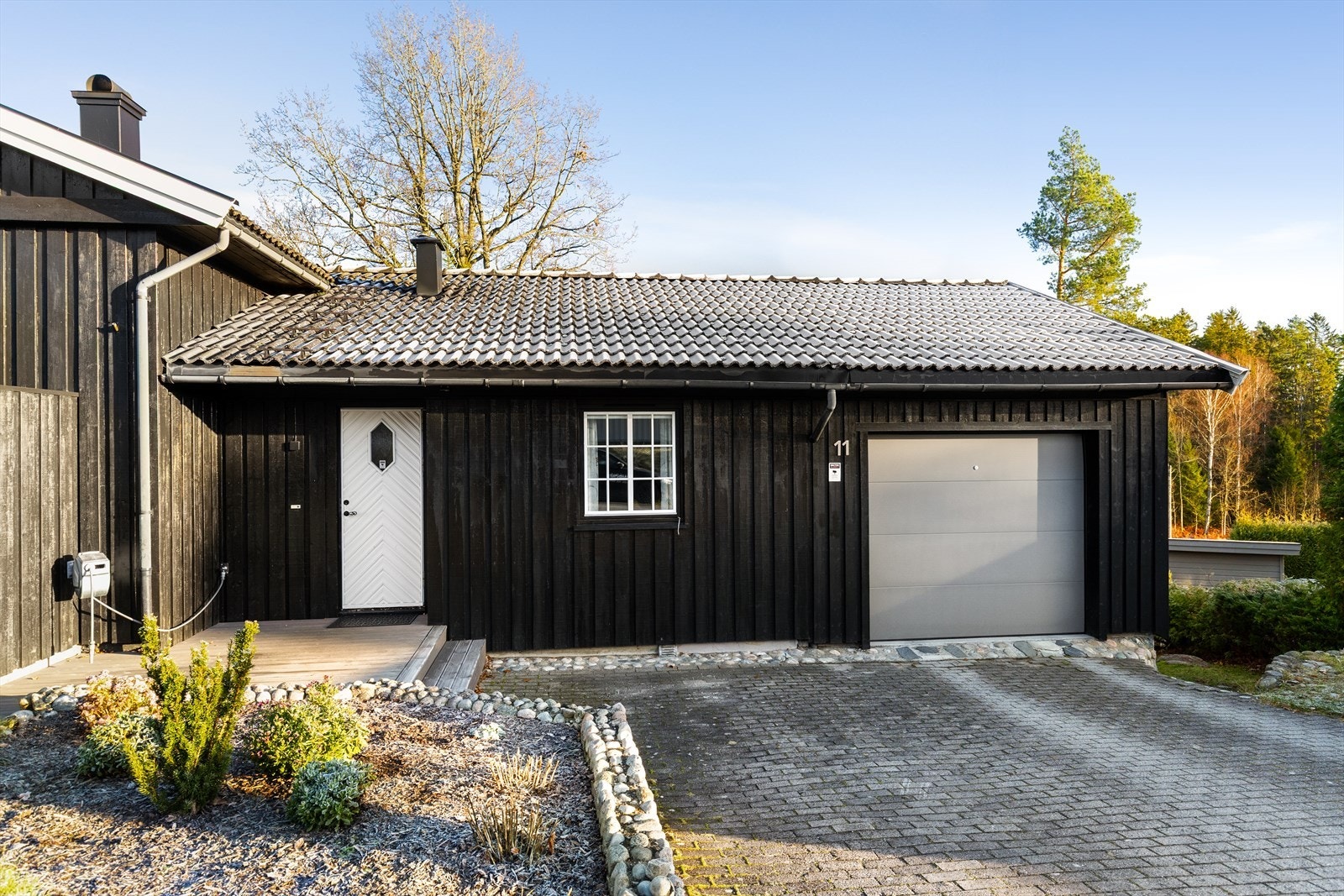 Innkjørselen er asfaltert og gir gode parkeringsmuligheter samt integrert carport/garasje. Galleribilde