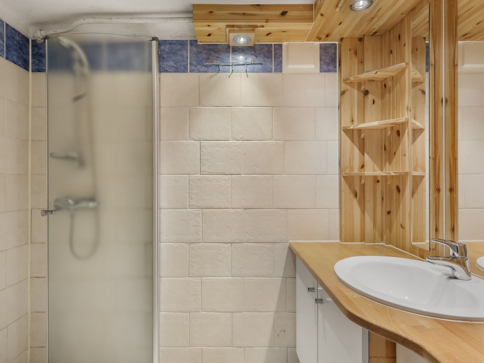 Kjelleren har bad med dusj, servant og flislagte overflater. Galleribilde