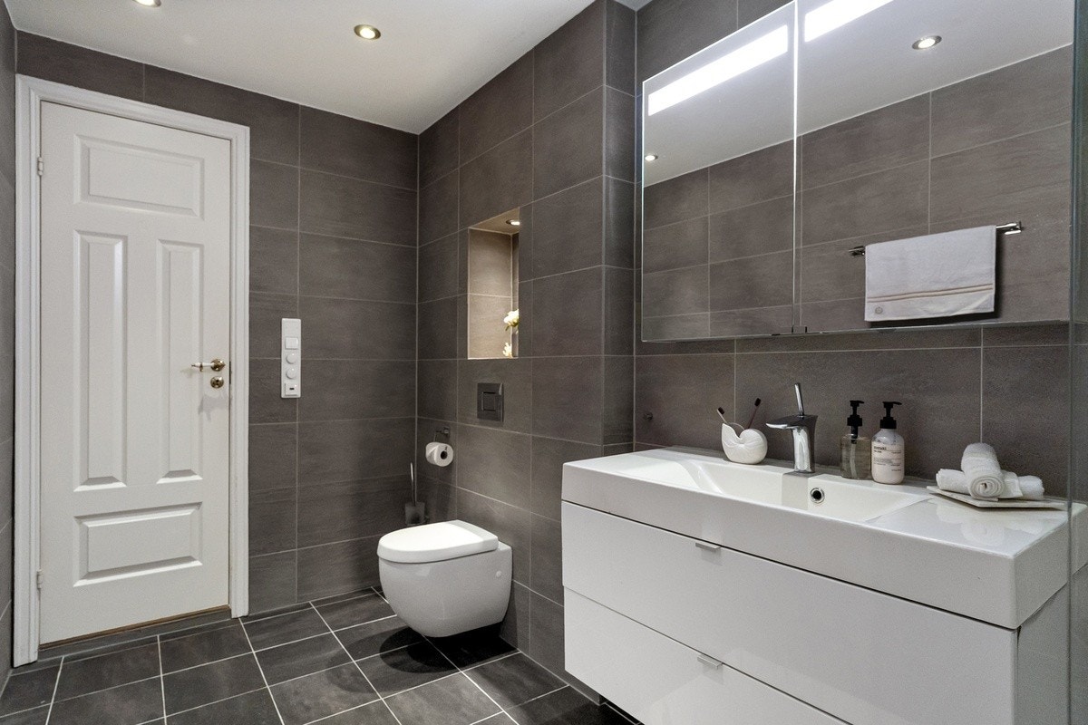 Innredningen består av hvite høyglans fronter med heldekkende servant og speilskap med integrert belysning Galleribilde