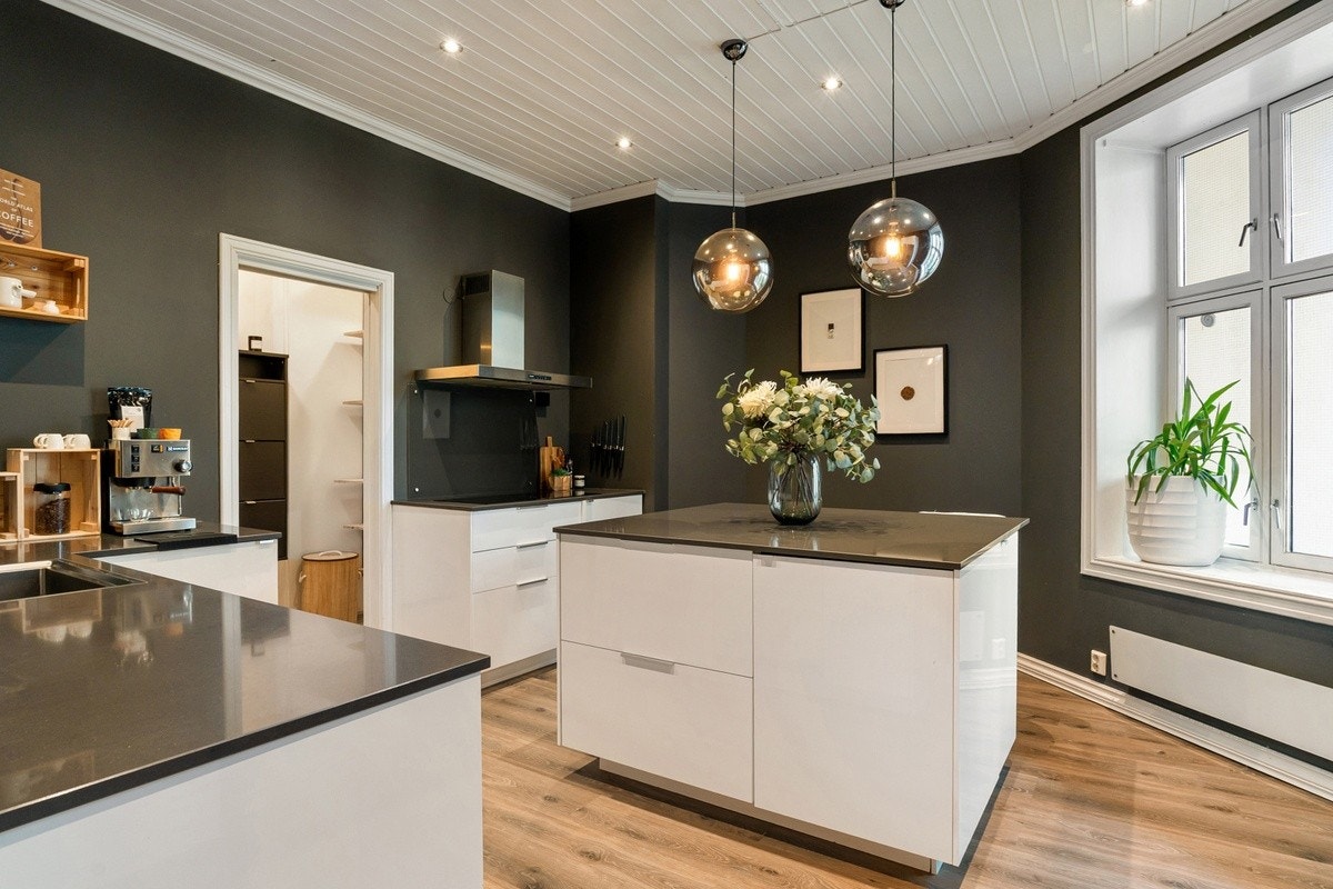 Kjøkkenet ligger adskilt fra stuen og har rikelig med både skap- og benkeplass Galleribilde