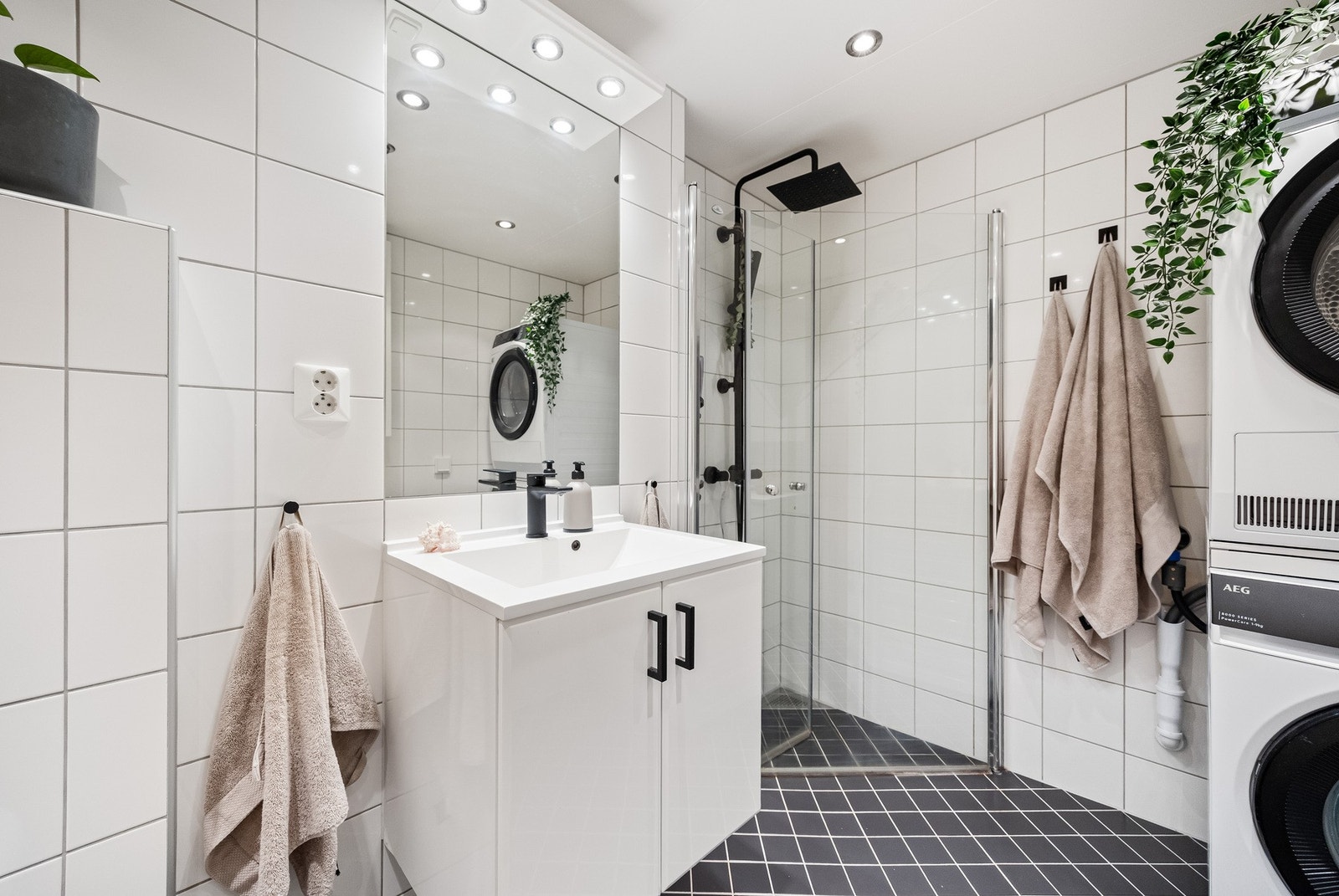 Innredningen består av servantinnredning, innmurt speil på vegg over servant, vegghengt toalett og dusjhjørne med svingbare glassdører. Galleribilde