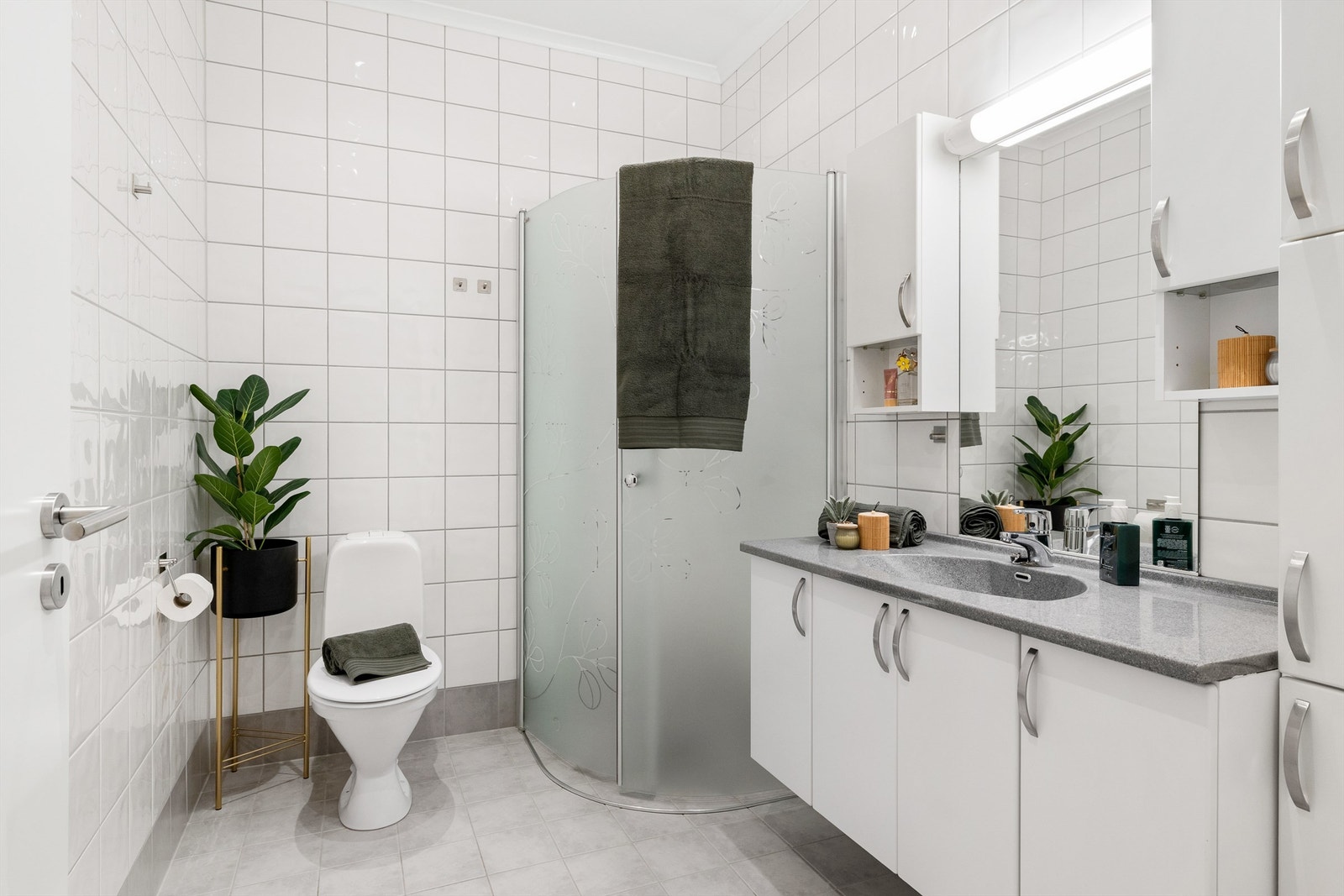 Romslig flislagt bad fra byggeåret med gulvvarme. Takene består av malte flater og har innfelte downlights. Galleribilde