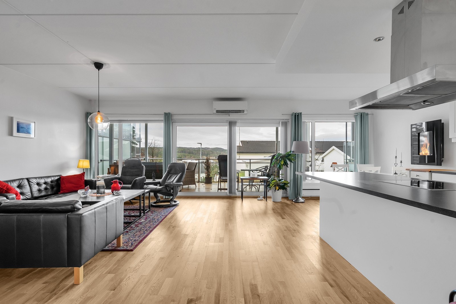 Åpen stue- og kjøkkenløsning med store vindusflater og rikelig lysinnslipp. Galleribilde