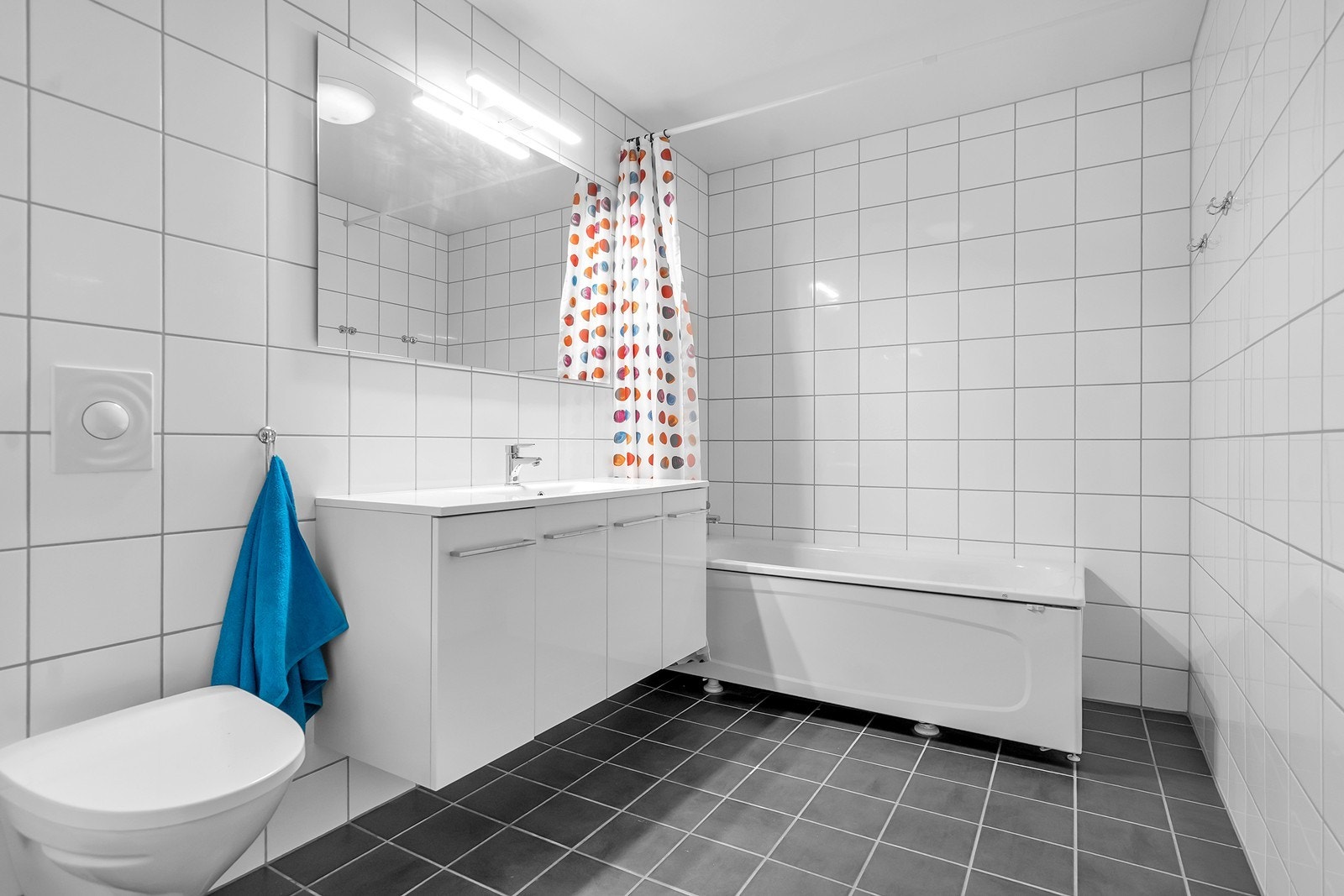 Leilighetens andre bad er flislagt og innredet med servantinnredning, toalett og badekar. Galleribilde