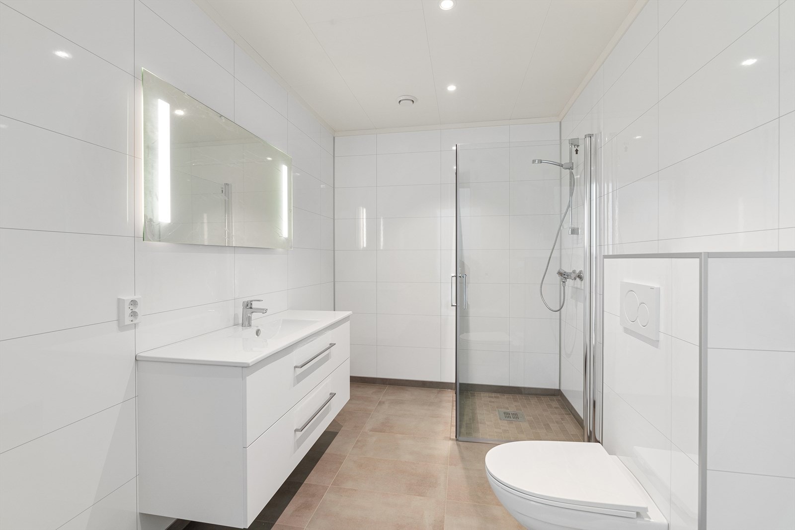 Lyst og lekkert bad med tidløse fliser, varmekabler i gulv og downlights i himling. Galleribilde