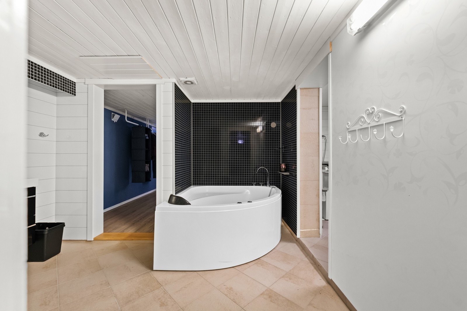 Bad med fliser, hjørnebadekar og lyse vegger. Galleribilde