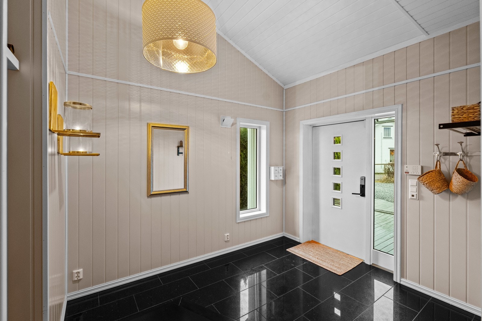 Lyst og romslig inngangsparti med moderne detaljer og god takhøyde. Galleribilde