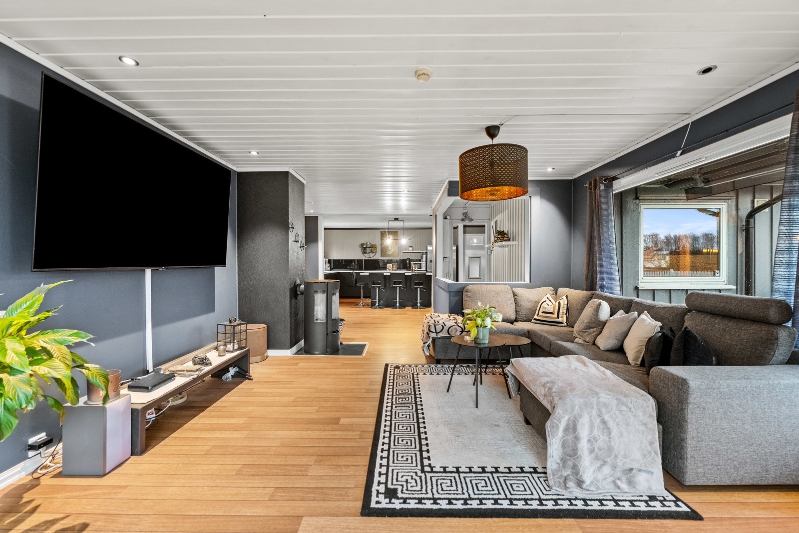 Romslig stue med åpen kjøkkenløsning og store vinduer som gir godt lysinnslipp. Galleribilde