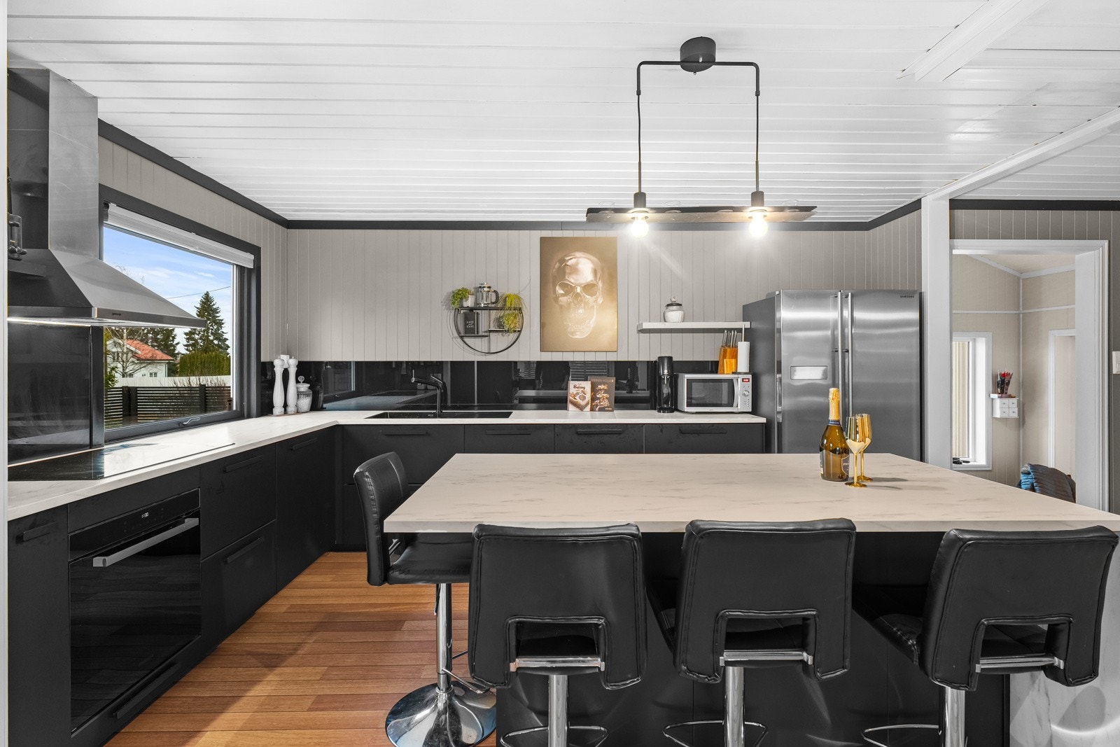 Lyst og moderne kjøkken med god benkeplass og integrerte hvitevarer. Galleribilde