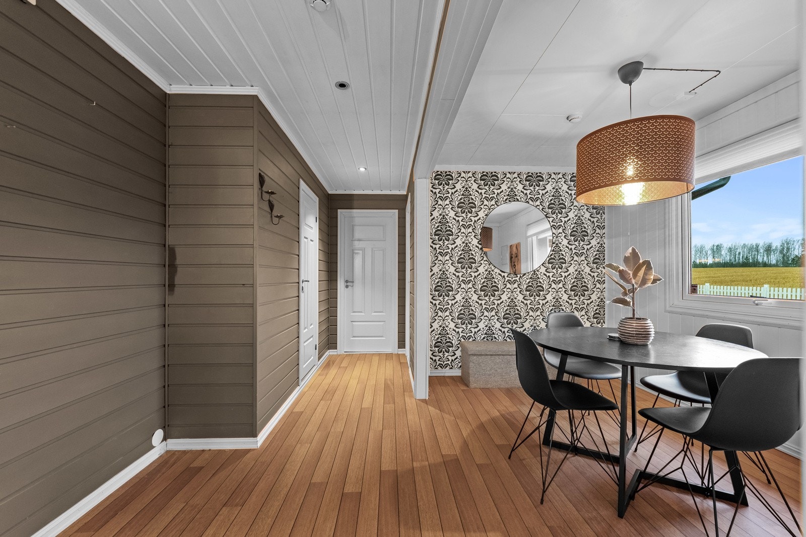 Rommet har lyse vegger, trepanel og et stort vindu som gir naturlig lys. Galleribilde